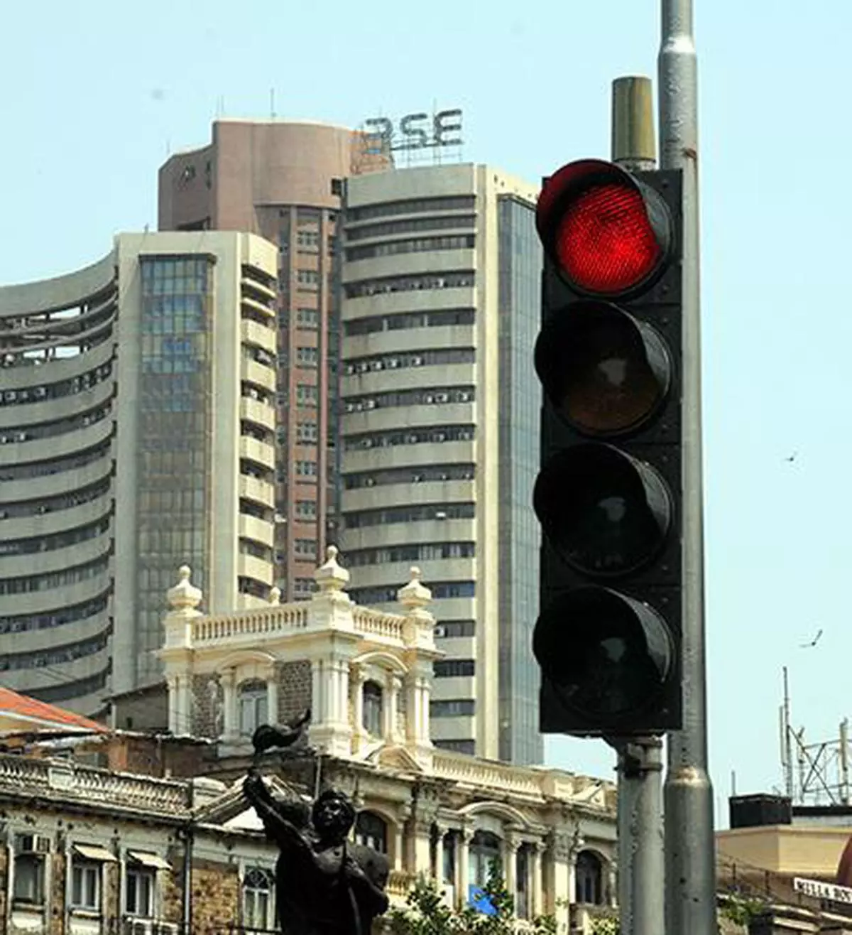 MUMBAI, MAHARASHTRA, 06/05/2015: A traffic signal in the foreground of the Bombay Stock Exchange on Dalal Street seems to reflect the mood of the stock markets in Mumbai