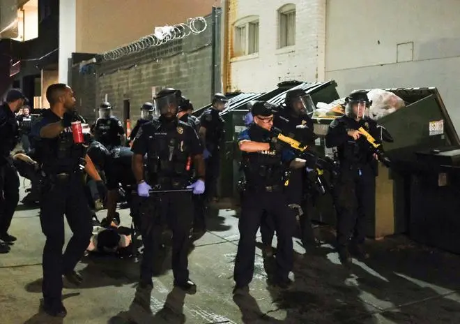 Law enforcement officers detain demonstrators during a rally in solidarity with Los Angeles protests against federal immigration sweeps, in Austin, Texas, U.S., June 9, 2025. 