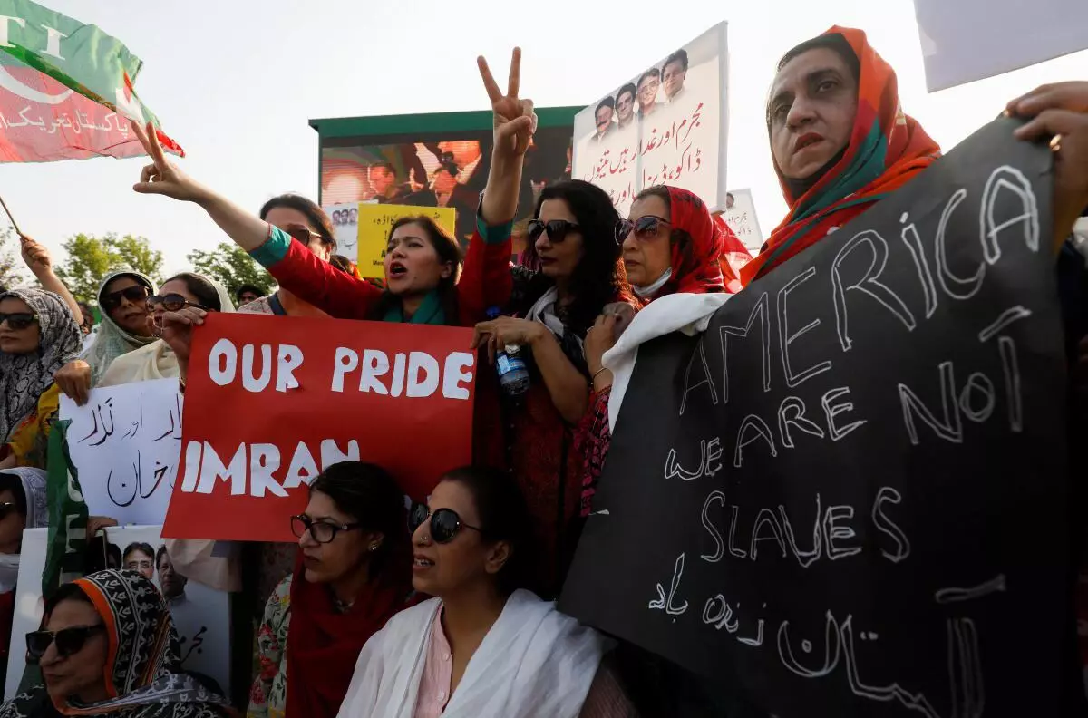 Supporters of the Pakistan Tehreek-e-Insaf (PTI) political party, carry signs as they chant slogans accusing the US of plotting to overthrow Pakistani Prime Minister Imran Khan, during a protest in Islamabad, Pakistan April 2, 2022. 