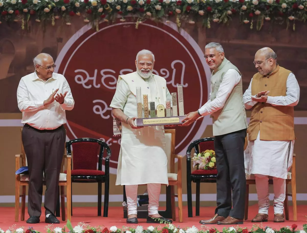 Prime Minister Narendra Modi receives a memento during a conclave on cooperative sector in Gandhinagar on Saturday