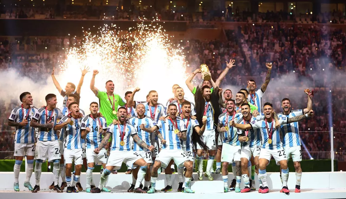 Argentina’s Lionel Messi lifts the World Cup trophy alongside teammates as they celebrate after winning the FIFA World Cup.