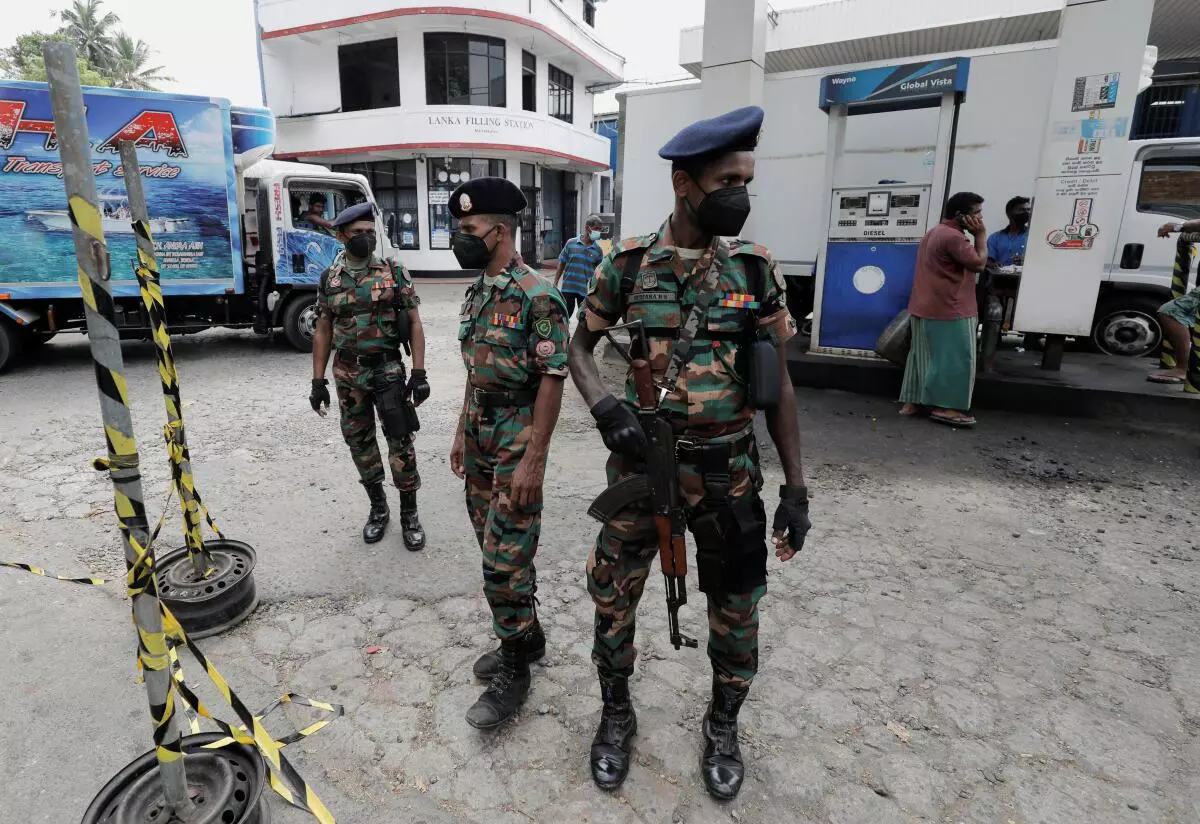 Sri Lanka‘s Army members stand guard at a Ceylon Petroleum Corporation fuel station to help stations distribute oil during the fuel crisis, in Colombo, Sri Lanka March 22, 2022. 