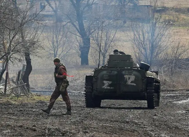 A service member of pro-Russian troops in a uniform without insignia walks next to an armoured vehicle with symbols “Z“ painted on its side in the separatist-controlled village of Bugas during Ukraine-Russia conflict in the Donetsk region, Ukraine March 6, 2022. A service member of pro-Russian troops in a uniform without insignia walks next to an armoured vehicle with symbols “Z“ painted on its side in the separatist-controlled village of Bugas during Ukraine-Russia conflict in the Donetsk region, Ukraine March 6, 2022.