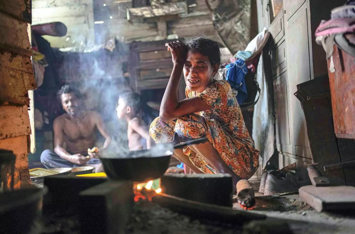 A woman sits by the fireplace at meal time in a shanty in Colombo, Sri Lanka. International creditors should provide debt relief to Sri Lanka to alleviate suffering as its people endure hunger, worsening poverty and shortages of basic supplies, Amnesty International said in a statement Wednesday