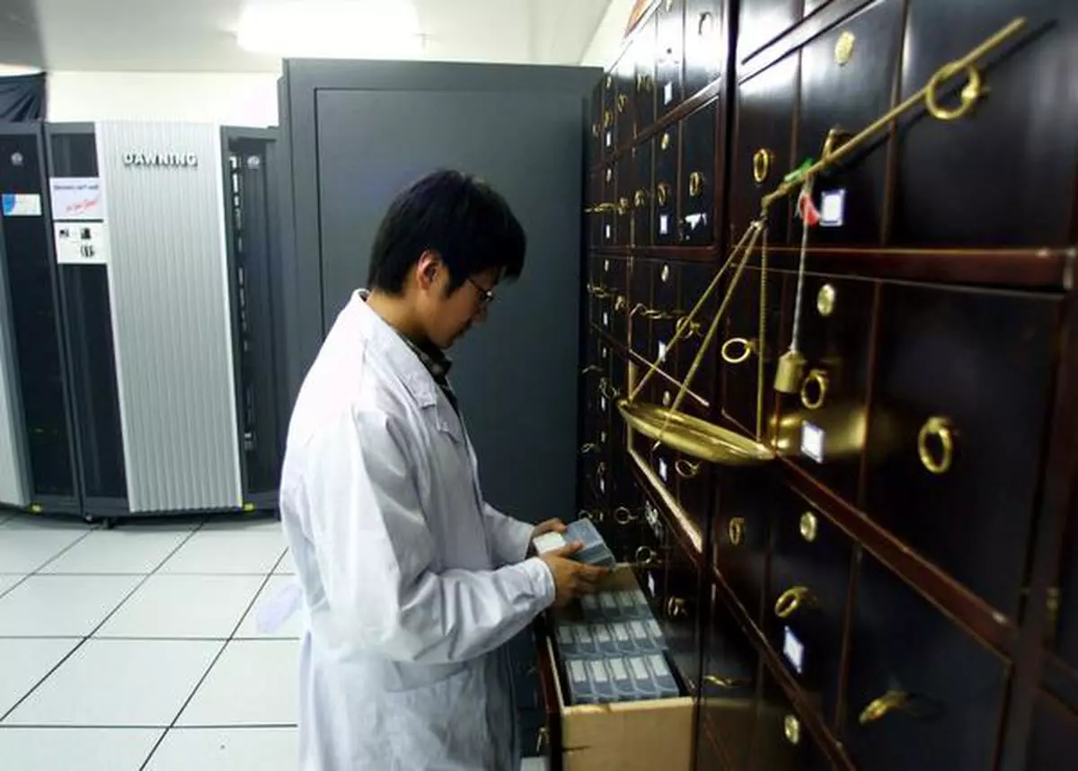 A CHINESE SCIENTIST LOOKS AT DATA TAPES STORED IN A TRADITIONAL CHINESE MEDICINE CUPBOARD ADJACENT TO A SUPERCOMPUTER AT THE BEIJING GENOMICS INSTITUTE IN CHINA'S CAPITAL. THE BEIJING GENOMICS INSTITUTE LAST WEEK PUBLISHED ONE OF THE TWO COMPLETE DRAFT OF THE GENES IN THE RICE PLANT. THE IDEA IS TO BE ABLE TO CULTIVATE CROPS THAT CAN RESIST DROUGHT, FLOODS, DISEASE AND CONTAMINATED SOIL, THAT WILL YIELD MORE USABLE FOOD PER PLANT AND THAT WILL GROW MORE QUICKLY. RICE IS THE STAPLE FOOD OF A THIRD TO A HALF OF THE WORLD'S POPULATION. - REUTERS *********************** A CHINESE SCIENTIST LOOKS AT DATA TAPES STORED IN A TRADITIONAL CHINESE MEDICINE CUPBOARD ADJACENT TO A SUPERCOMPUTER AT THE BEIJING GENOMICS INSTITUTE IN CHINA'S CAPITAL APRIL 11, 2002. THE BEIJING GENOMICS INSTITUTE LAST THURSDAY PUBLISHED ONE OF THE TWO COMPLETE DRAFT OF THE GENES IN THE RICE PLANT. THE IDEA IS TO BE ABLE TO CULTIVATE CROPS THAT CAN RESIST DROUGHT, FLOODS, DISEASE AND CONTAMINATED SOIL, THAT WILL YIELD MORE USABLE FOOD PER PLANT AND THAT WILL GROW MORE QUICKLY. RICE IS THE STAPLE FOOD OF A THIRD TO A HALF OF THE WORLD'S POPULATION. REUTERS/ANDREW WONG