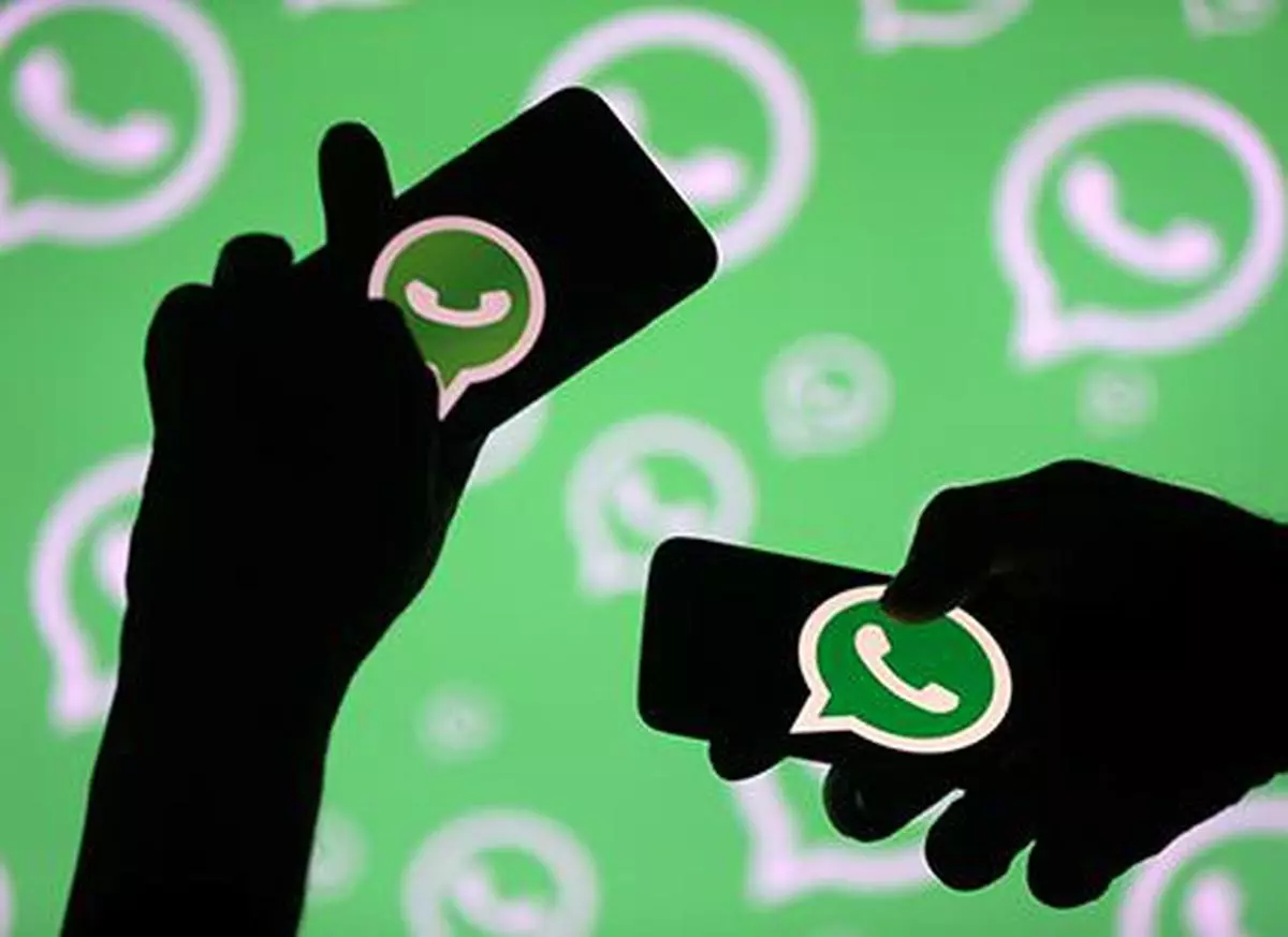 FILE PHOTO: Men pose with smartphones in front of displayed Whatsapp logo in this illustration September 14, 2017. REUTERS/Dado Ruvic/File Photo