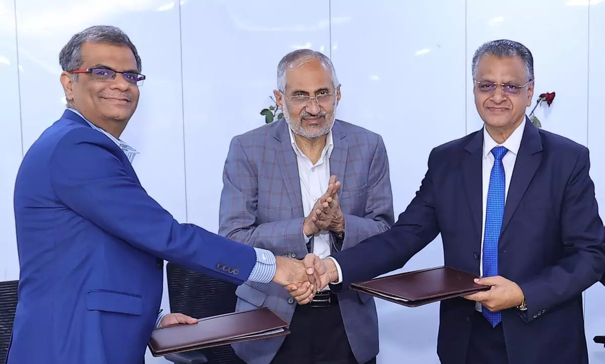 Mahabaleshwara MS (right), Managing Director and Chief Executive Officer of the bank, and Mahesh Makhija from EY at the launching of Analytical Centre of Excellence (ACoE) of the bank in Bengaluru. Pradeep Kumar (centre), Chairman of the bank, is seen.