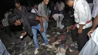 People search for their belongings amongst shoes left behind during a stampede in the eastern Indian city of Patna October 3, 2014. At least 32 people were killed in a stampede during a Hindu festival in the eastern Indian state of Bihar on Friday, the state police chief said. A huge crowd had gathered at an outdoor venue in the state capital Patna for the burning of effigies at dusk, part of the Dusshera festival. REUTERS/Stringer (INDIA - Tags: RELIGION DISASTER)