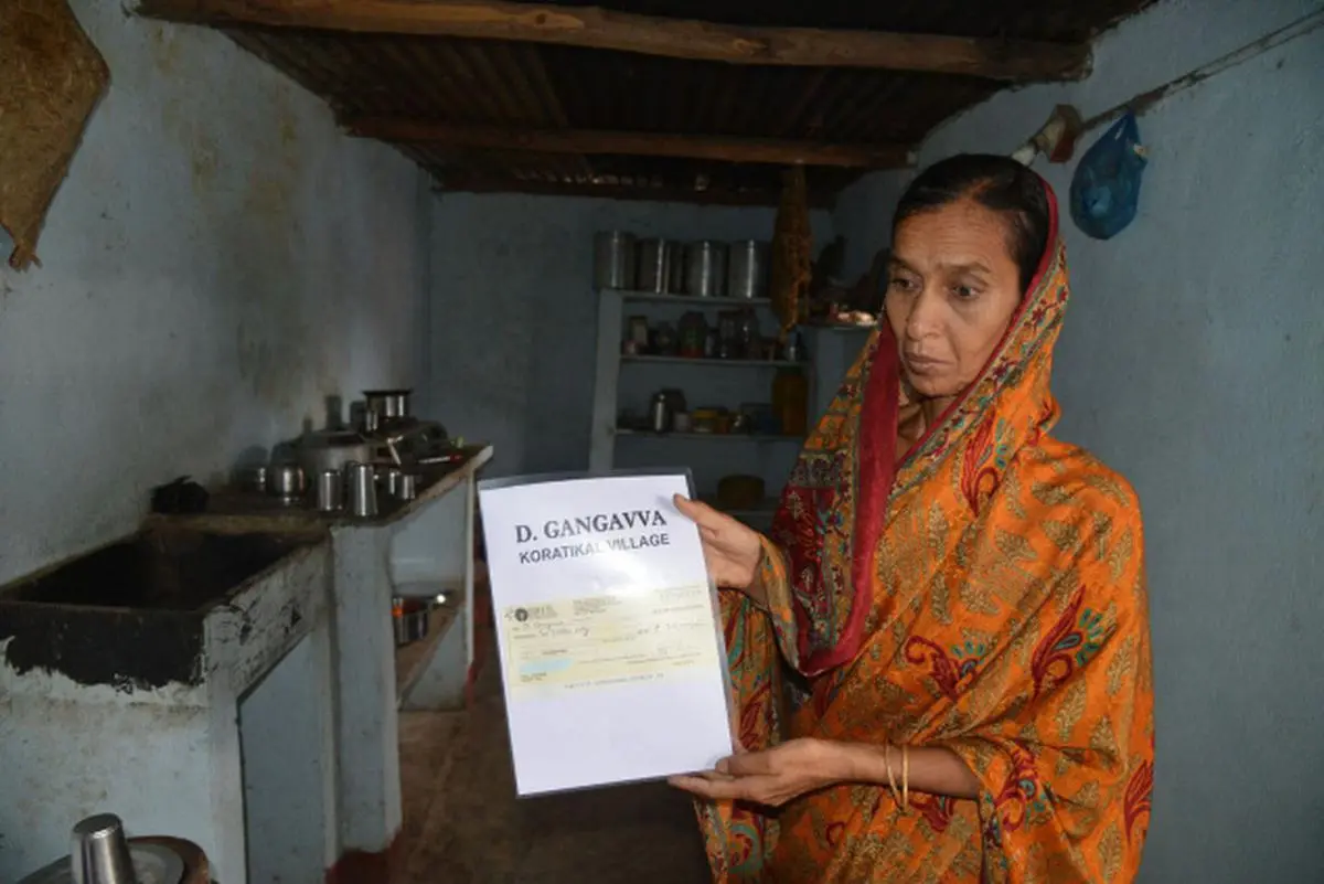 Velma Gangavva, wife of farmer Rajeshwar, displaying the cheque for Rs. 2 lakh handed over by AICC vice president Rahul Gandhi. Photo: Nagara Gopal