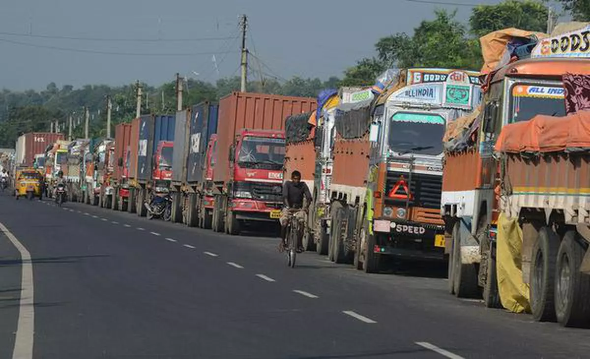 A file photo of a man cycling past parked Indian trucks carrying goods to Nepal near the India-Nepal border at Panitanki, 40 km from Siliguri  AFP