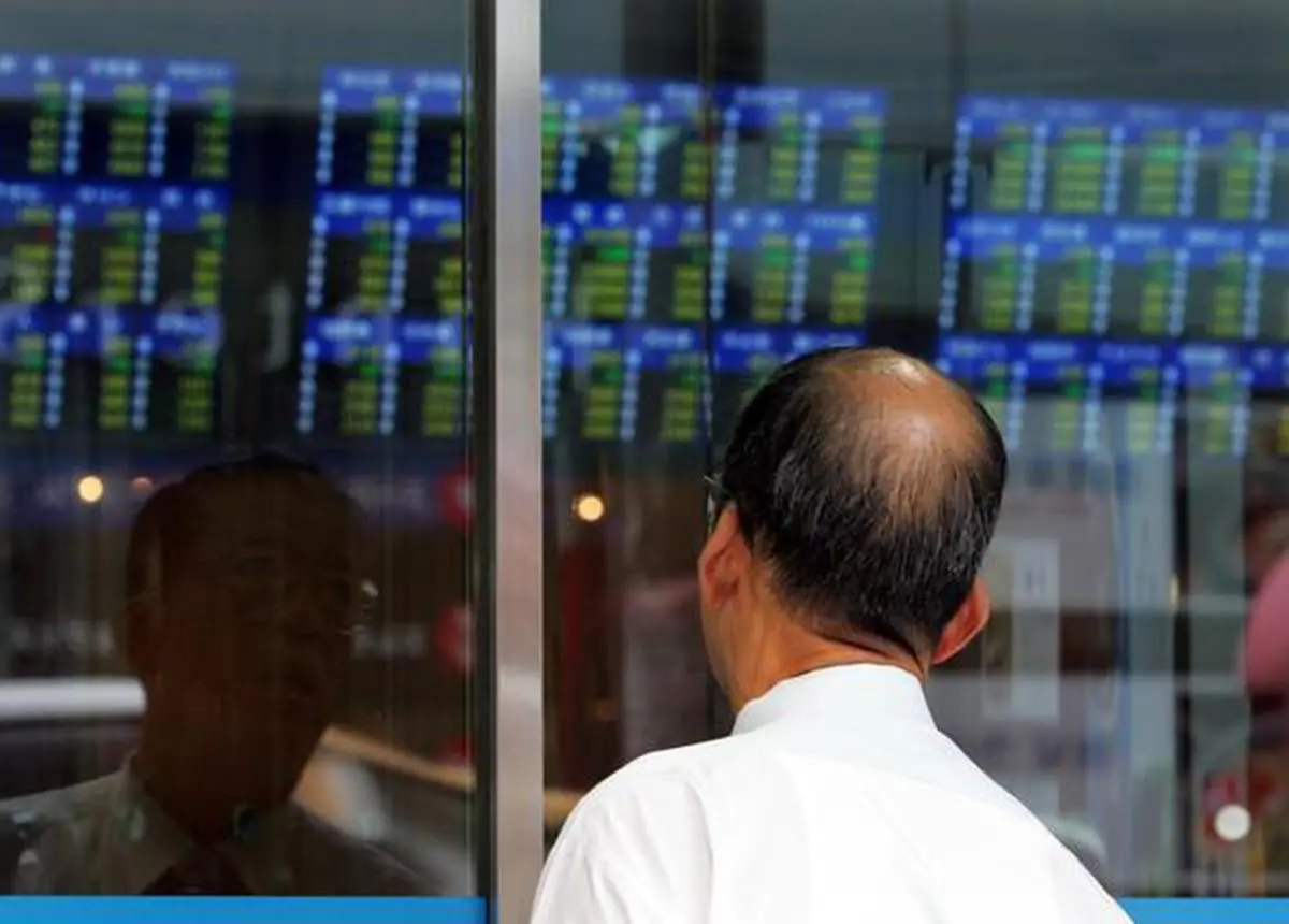 A man looks through a window to check share prices at a securities firm in Tokyo July 14, 2006. The Nikkei fell 1.67 percent to end below 15,000 on Friday, its lowest close in three weeks, as investors took a Bank of Japan interest rate hike in their stride and sold stocks on worries over the impact of higher oil prices and corporate profits.  REUTERS/Yuriko Nakao (JAPAN)