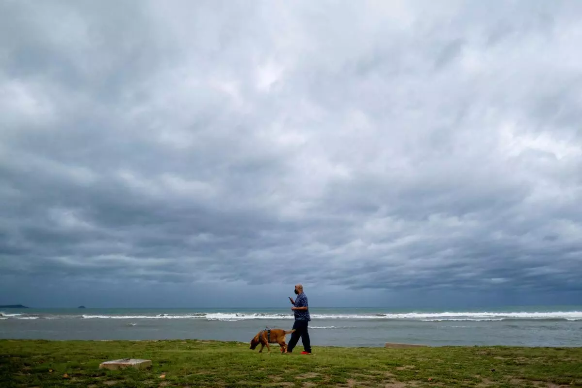 A man walks his dog as tropical storm Fiona and its heavy rains approach in Ponce, Puerto Rico September 18, 2022. REUTERS