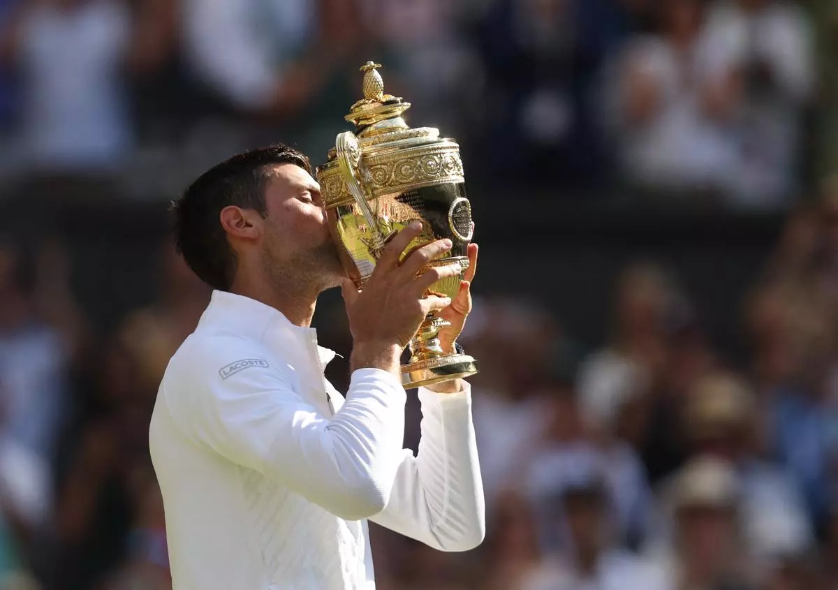 Novak Djokovic celebrates with the trophy after winning the men’s singles final against Australia’s Nick Kyrgios
