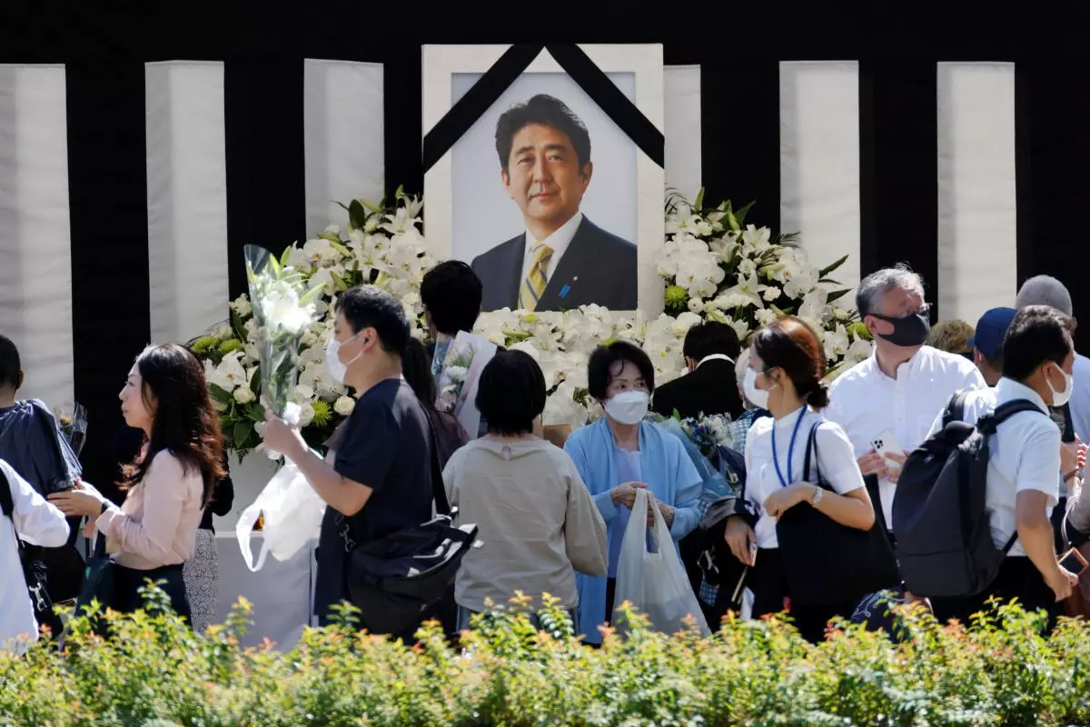 Mourners lay flowers and pay their respects at the altar outside Nippon Budokan Hall, which will host a state funeral for former Prime Minister Shinzo Abe, in Tokyo, Japan September 27, 2022. REUTERS