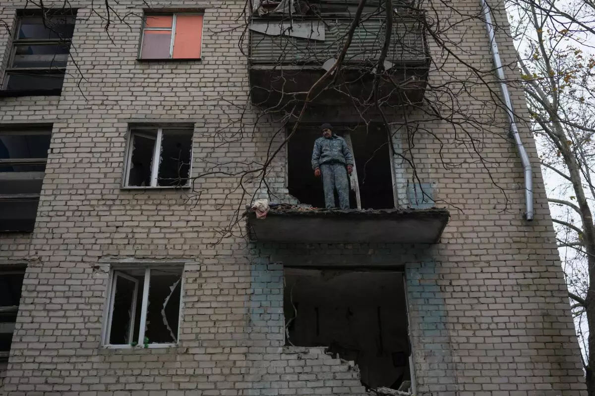 Oleksandr Antonenko, 53, stands on a balcony of his apartment damaged by a recent Russian military strike in Kherson, Ukraine November 27, 2022. REUTERS