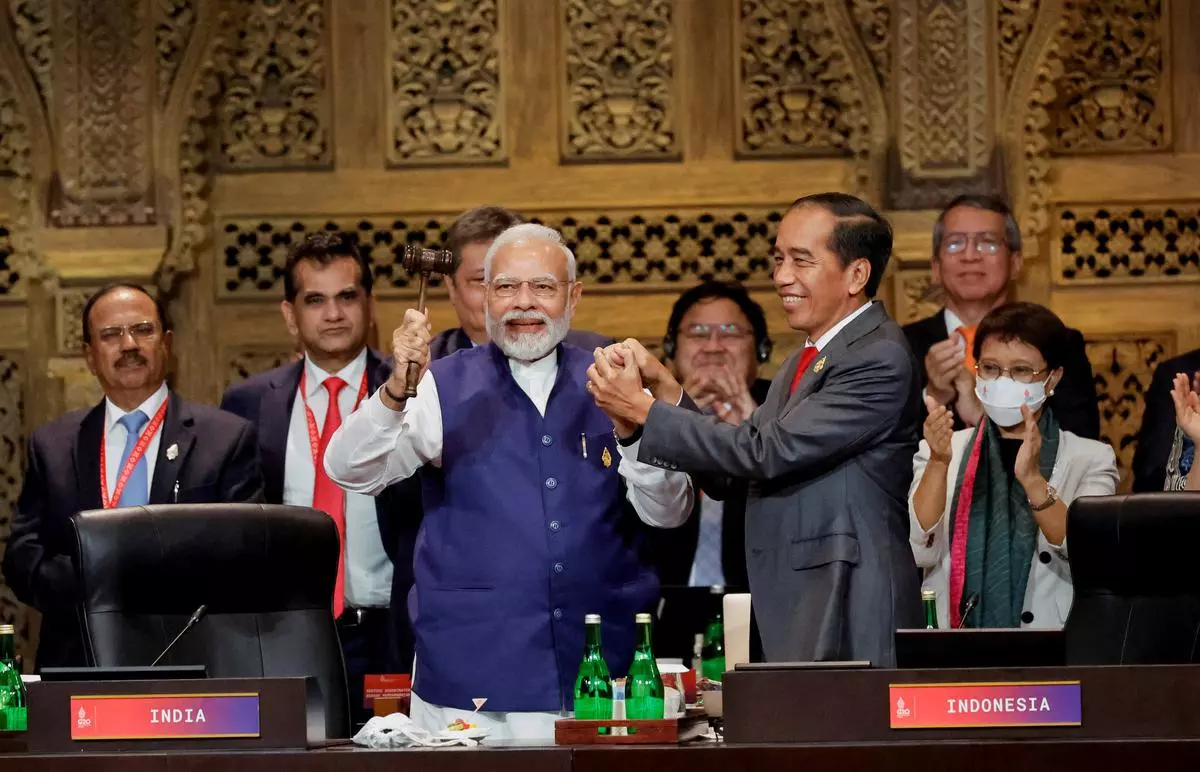 Prime Minister Narendra Modi and Indonesia’s President Joko Widodo hold hands during the handover ceremony at the G20 Leaders’ Summit