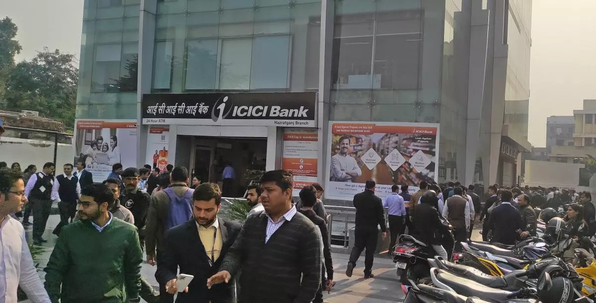 Bank staff came out of a building after a tremor was felt in Lucknow on Tuesday. An earthquake with a magnitude of 5.8 on the Richter scale hit the northern part of India with its epicentre in Nepal. (PHOTO: SANDEEP SAXENA)