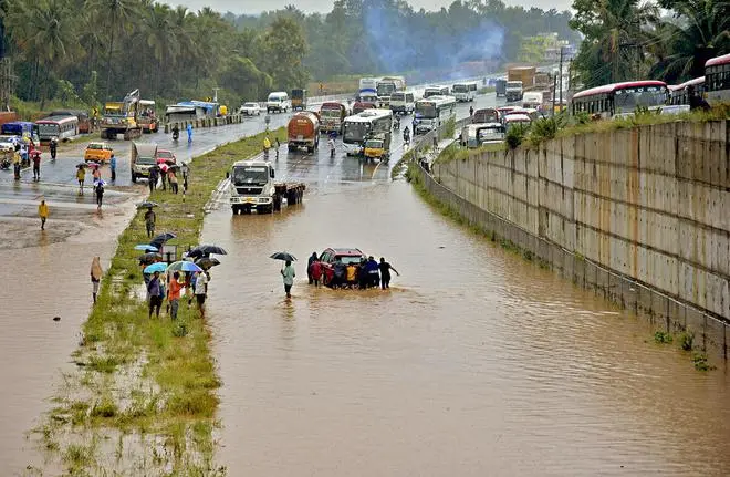 People push a car stuck on the flooded Bengaluru-Mysuru highway following a heavy monsoon downpour at Ramnagar, Karnataka, Monday, August 29, 2022. (PTI) People push a car stuck on the flooded Bengaluru-Mysuru highway following a heavy monsoon downpour at Ramnagar, Karnataka, Monday, August 29, 2022. (PTI)