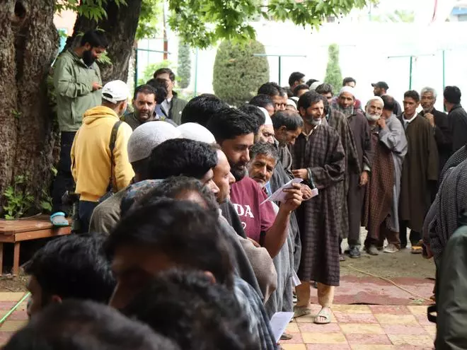 Voters wait in a queue to cast their votes on Monday