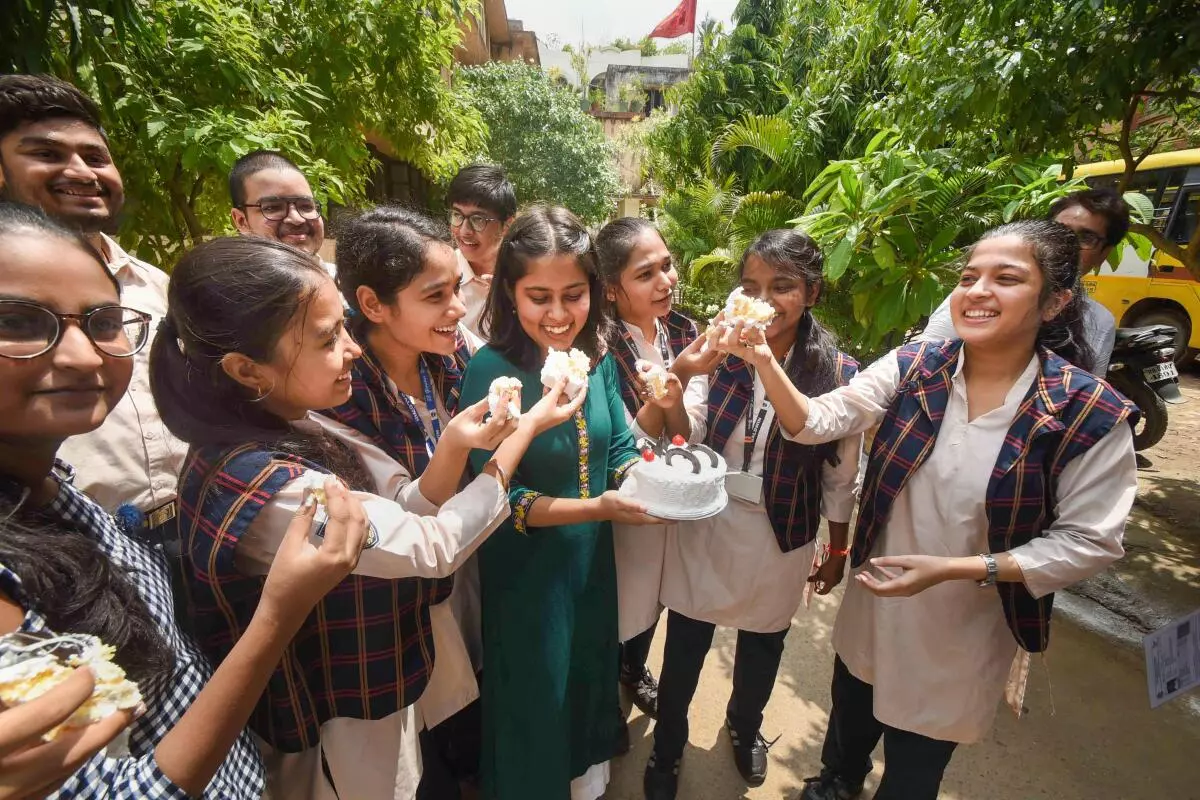 Students cut a cake to celebrate their success after the announcement of the Central Board of Secondary Education (CBSE) exam results, in Patna, Friday, July 22, 2022. (PTI)
