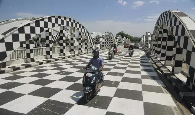 Vehicles ply on the Napier bridge, painted in a black and white checkered pattern, ahead of the 44th International Chess Olympiad at Mamallapuram near Chennai, Saturday, July 16, 2022. The event will be held from July 28 to August 10. (PTI)