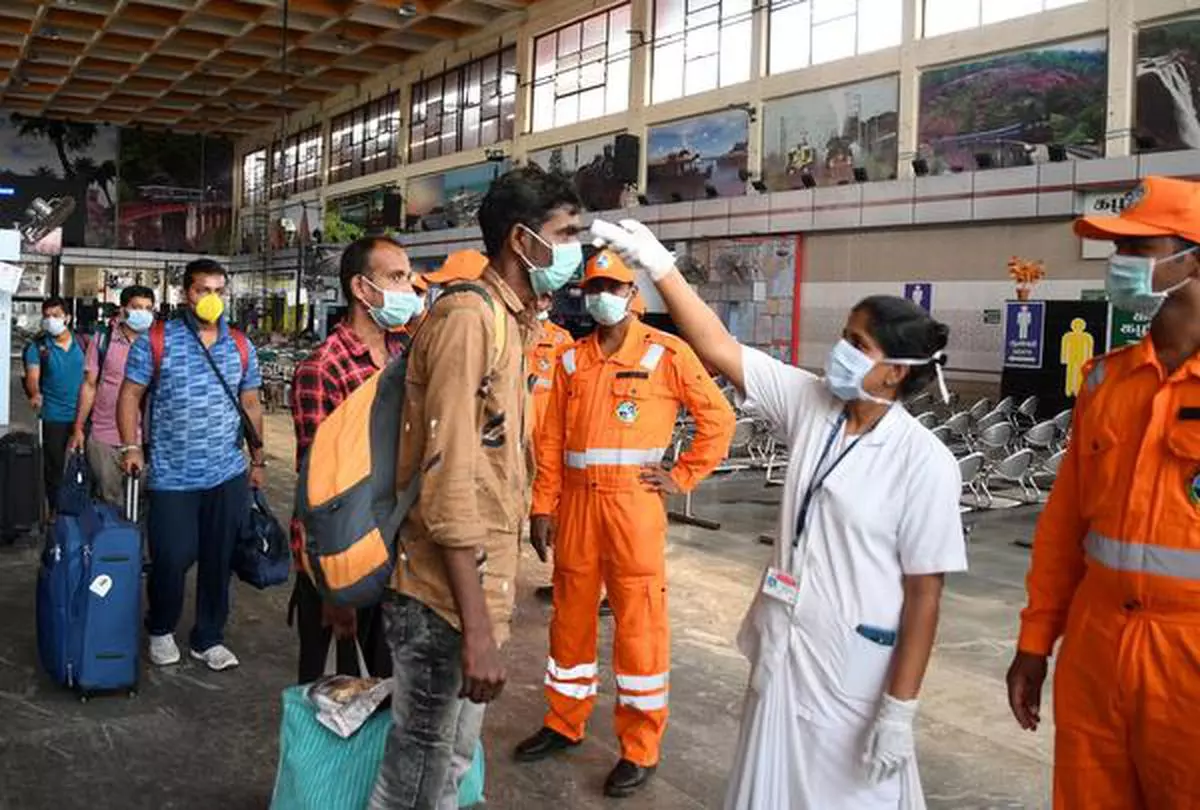 Nursing staff with face mask seen checking a passenger with the Thermal Screening Device at a Coronavirs Screening Help desk centre at Chennai Central railway station.
