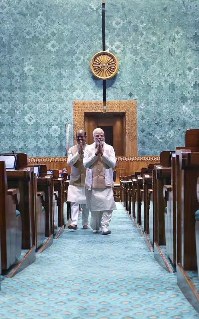 Prime Minister Narendra Modi walks into the Lok Sabha chamber of the new Parliament building, in New Delhi, Sunday, May 28, 2023. Lok Sabha Speaker Om Birla is also seen. (PIB Photo)