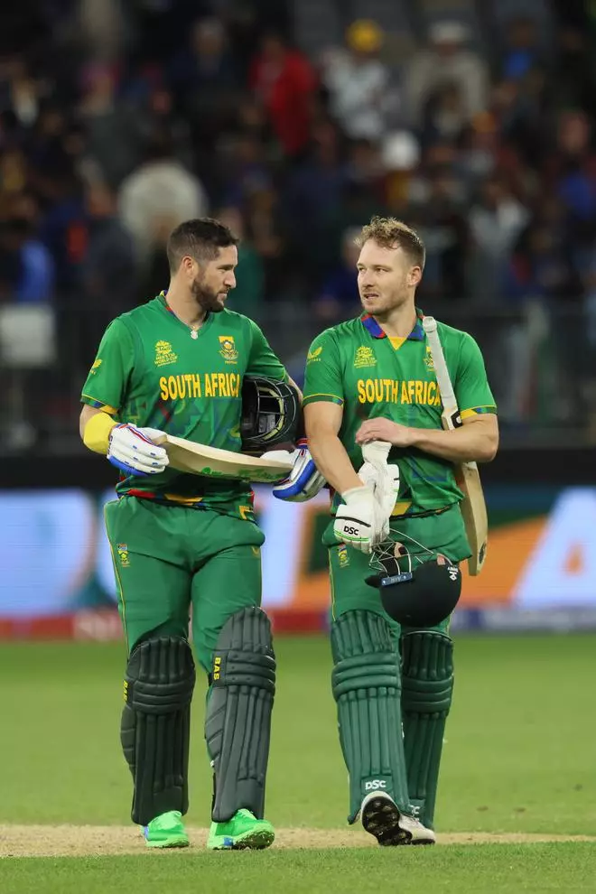 South Africa’s Wayne Parnell (L) and David Miller walk back to the pavilion after their victory at the end of the ICC men’s Twenty20 World Cup 2022 cricket match between India and South Africa at the Perth Stadium