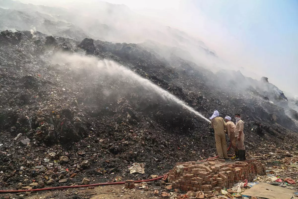 Firefighters douse a fire at the Bhalswa landfill in New Delhi on Thursday