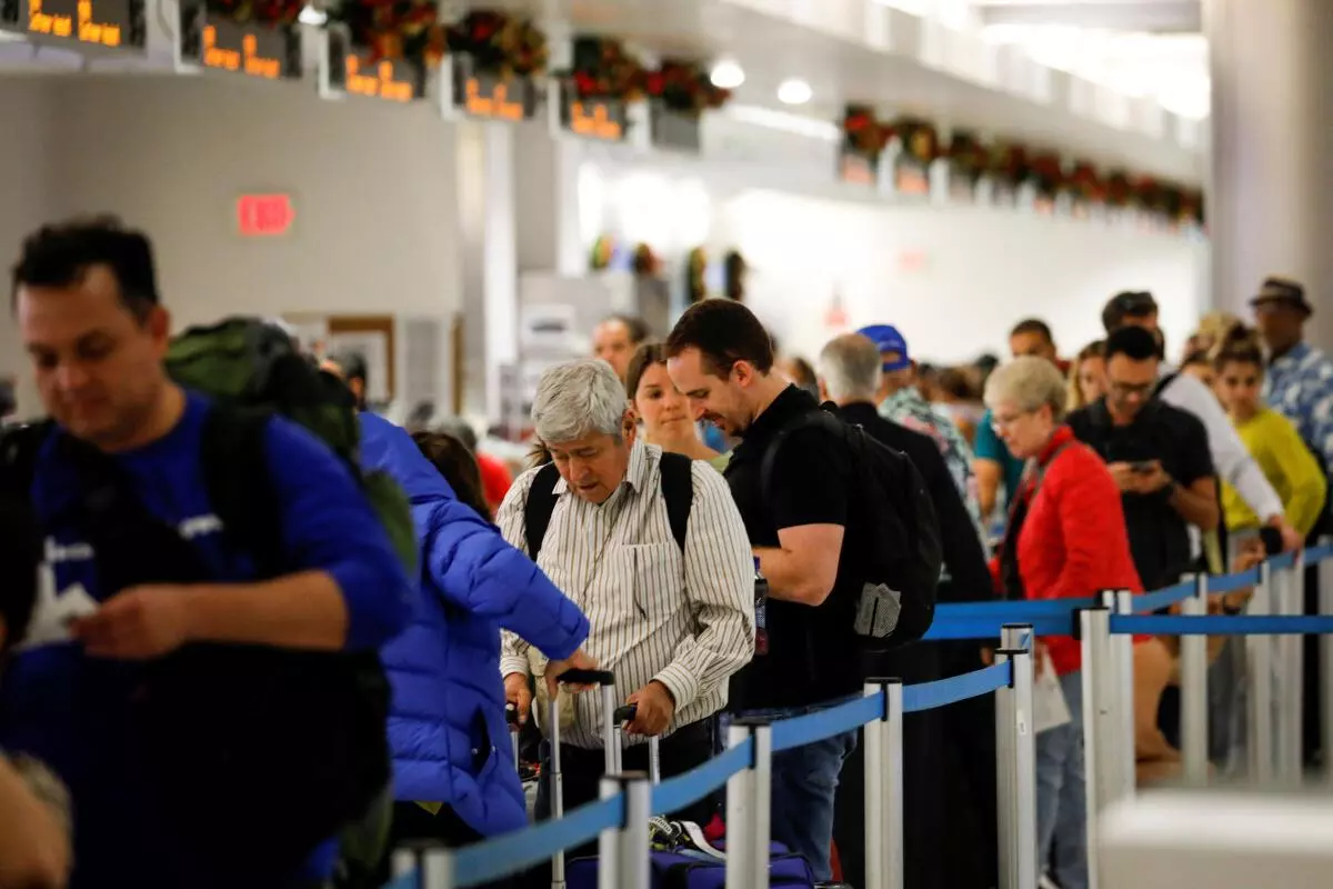 Travelers queue to check in for their flights at Miami International Airport after the Federal Aviation Administration (FAA) said it had slowed the volume of airplane traffic over Florida due to an air traffic computer issue, in Miami, Florida, US. REUTERS