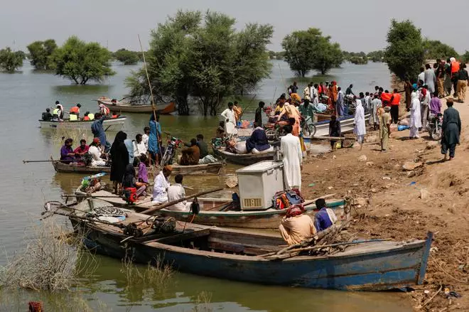 Flood victims use boats to reach their villages, following rains and floods during the monsoon season in Sehwan, Pakistan, September 16, 2022. REUTERS