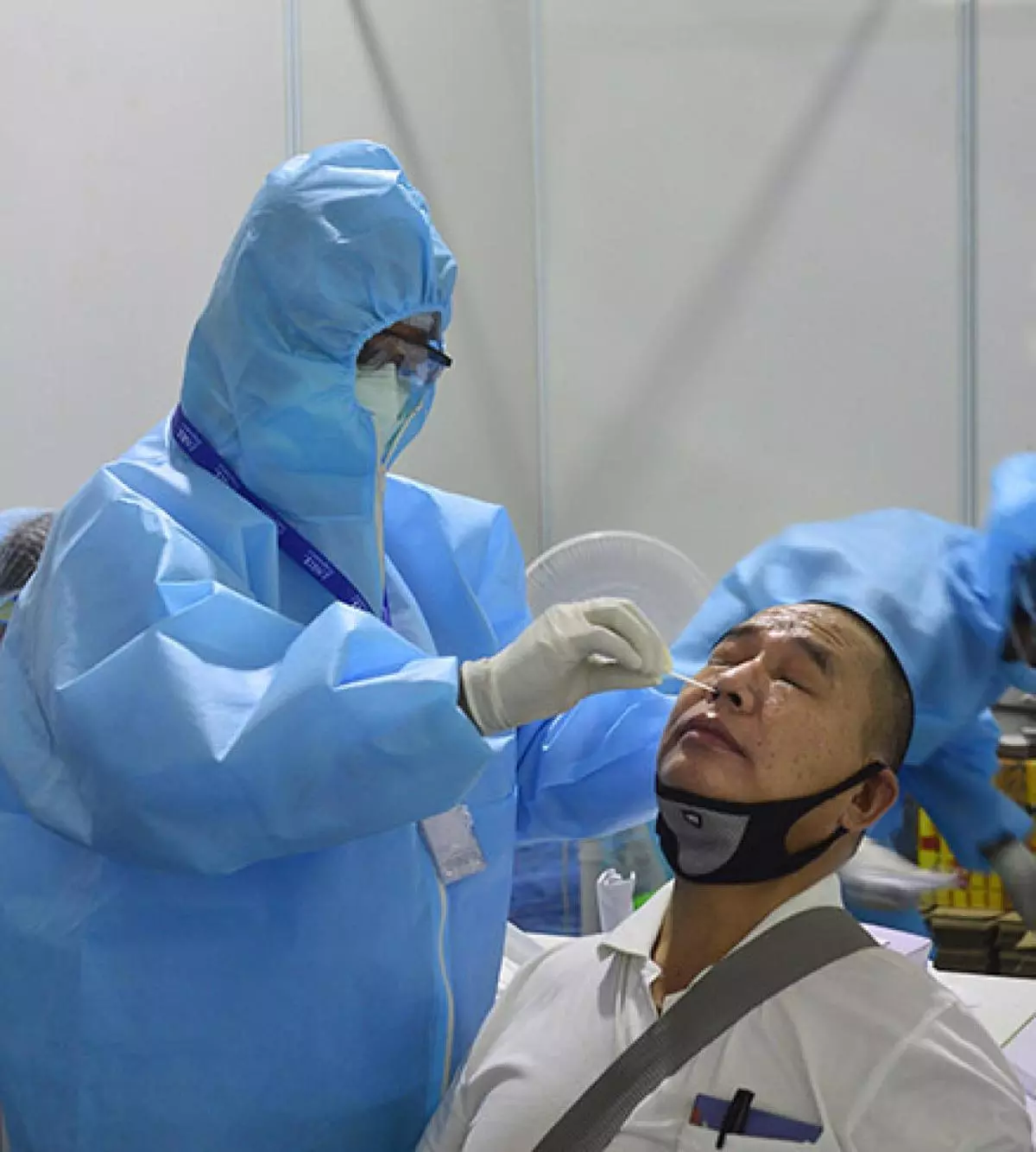 A health worker collects a swab sample of a person at Dr Ram Manohar Lohia Hospital in New Delhi. (PTI/File photo)