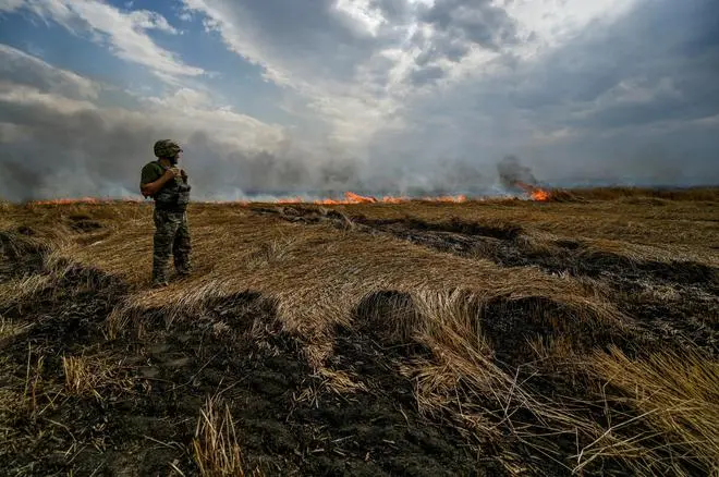 A Ukrainian serviceman stands on a burning wheat field near a frontline on a border between Zaporizhzhia and Donetsk regions, as Russia’s attack on Ukraine continues, Ukraine July 17, 2022. REUTERS A Ukrainian serviceman stands on a burning wheat field near a frontline on a border between Zaporizhzhia and Donetsk regions, as Russia’s attack on Ukraine continues, Ukraine July 17, 2022. REUTERS