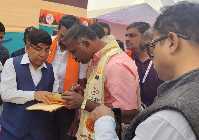 MoS Subhas Sarkar exchanges a postcard with a Yatri who is part of the Kashi-Tamil Sangam. MoS Subhas Sarkar exchanges a postcard with a Yatri who is part of the Kashi-Tamil Sangam.