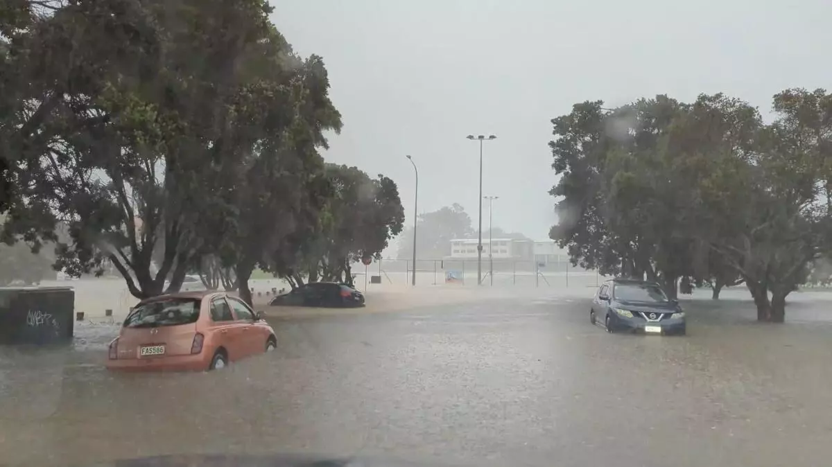 Cars are seen in a flooded street during heavy rainfall in Auckland, New Zealand January 27, 2023, in this screen grab obtained from a social media video. REUTERS