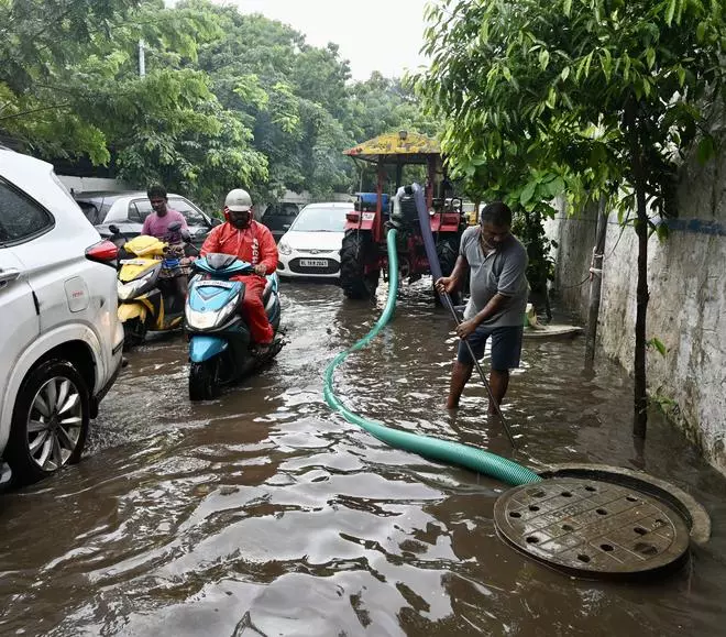 Greater Chennai Corporation staff pumping out water from stagnated streets