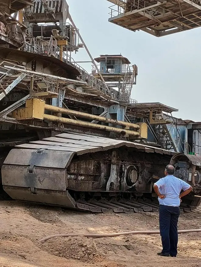 A man stands next to the tracks of NLC’s 30-meters tall Bucket Wheel Excavator that can scoop out 2.4 lakh cubic metres of earth per day weighing as much as 8,600 cars. A man stands next to the tracks of NLC’s 30-meters tall Bucket Wheel Excavator that can scoop out 2.4 lakh cubic metres of earth per day weighing as much as 8,600 cars.