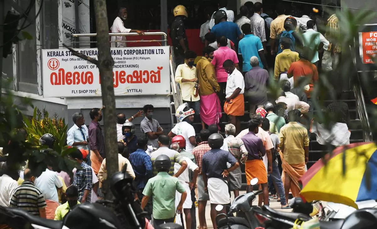 Customers queuing up in front of a Kerala State Beverages Corporation (Bevco) out in Kochi on Sunday just a few hours before the start of the two-day shut down called by trade unions across the country. (Thulasi Kakkat/The Hindu)
