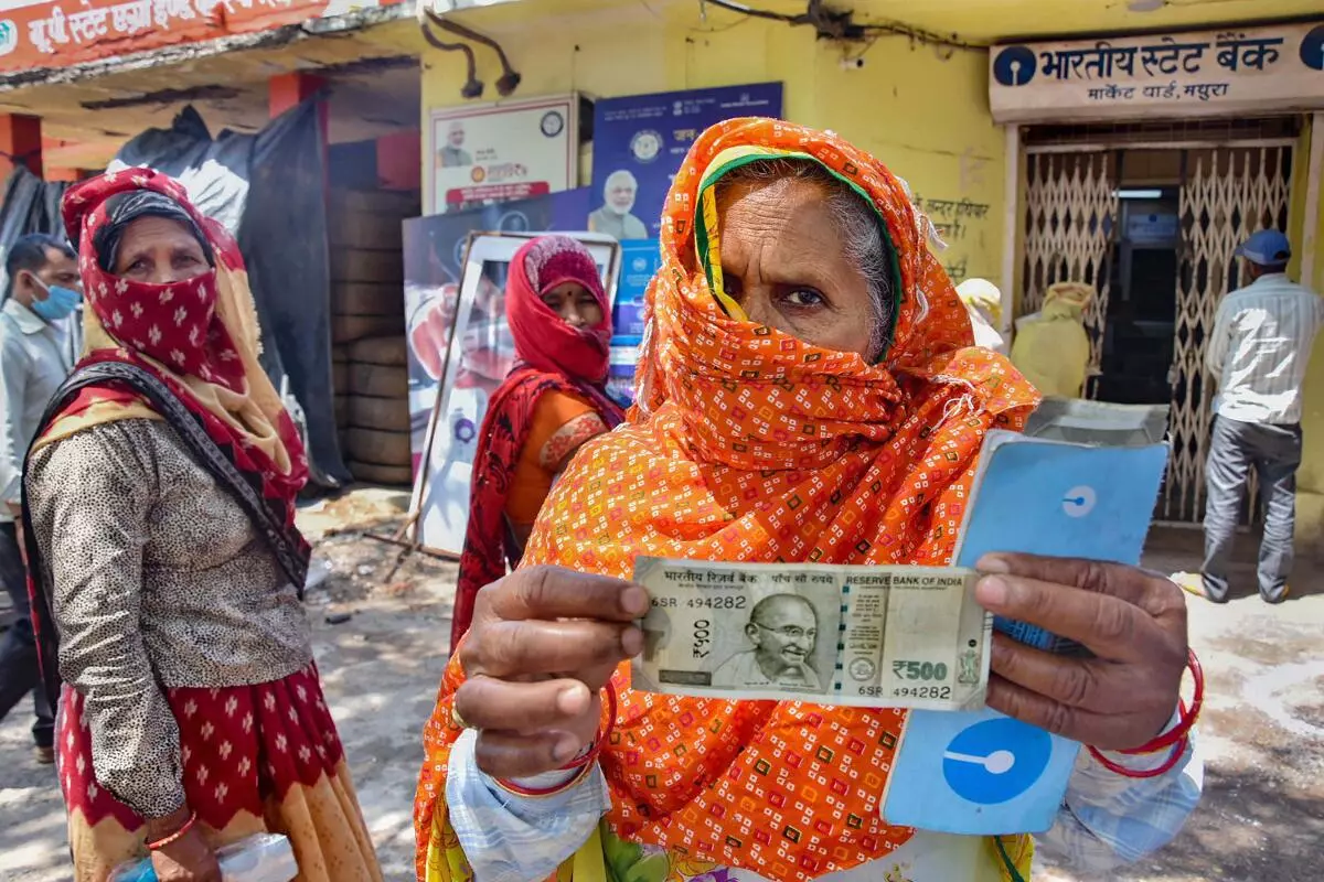 An elderly woman shows a 500 rupee note after withdrawing from her Jan Dhan account in Mathura (PTI)