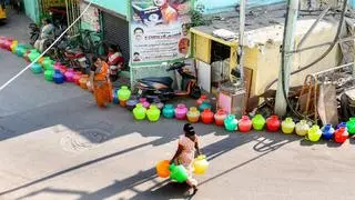 People waiting for water with empty plastic pots at Metro water tank taps. File Photo
