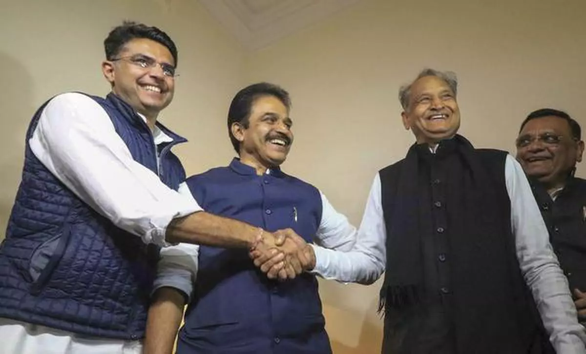 Congress leaders Ashok Gehlot (R) and Sachin Pilot (L) shake hands as K.C. Venugopal looks on after the declaration of Rajasthan Assembly election result, in Jaipur, on Tuesday. 