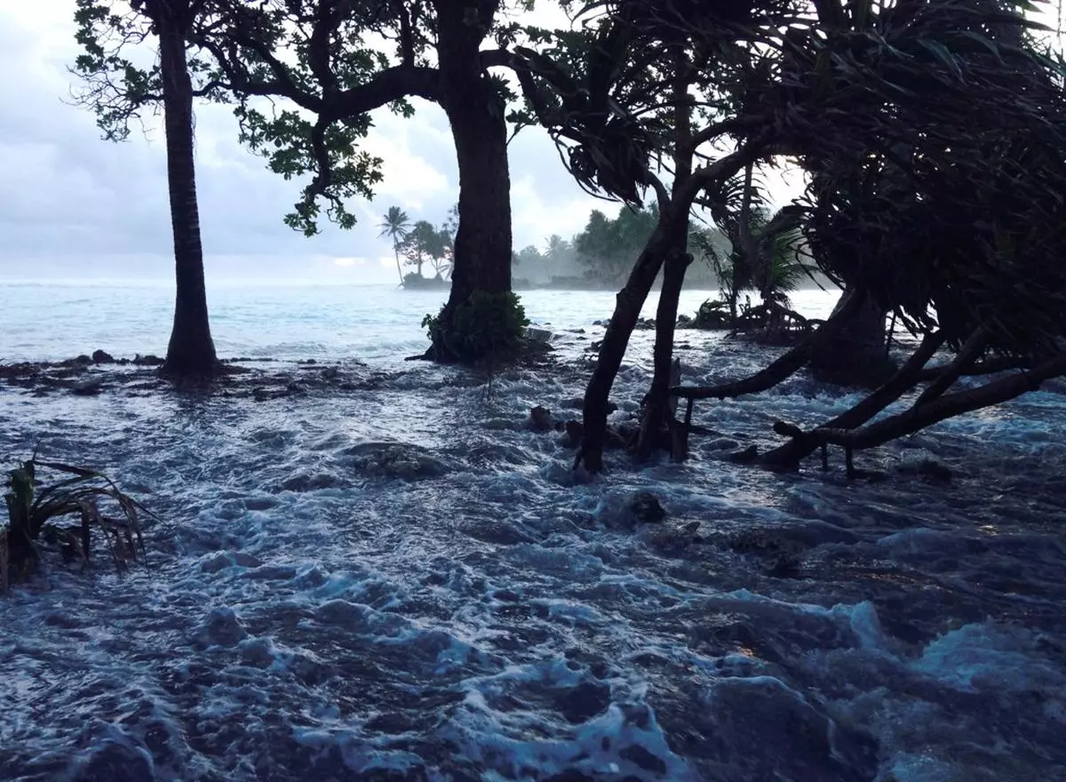 A high tide energized by storm surges washes across Ejit Island in Majuro Atoll, Marshall Islands in March 2014 (Photo by GIFF JOHNSON / AFP)