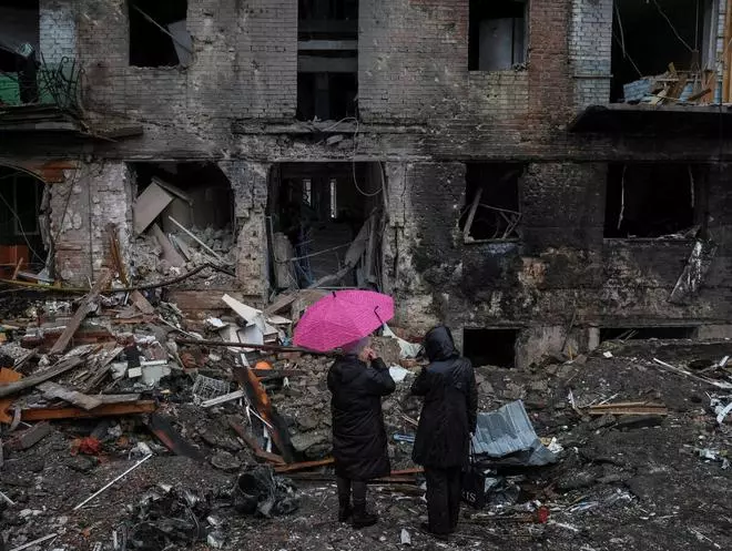 Local residents stand near their building destroyed by a Russian missile attack, as Russia’s attack on Ukraine continues, in the town of Vyshhorod, near Kyiv, Ukraine November 24, 2022. REUTERS