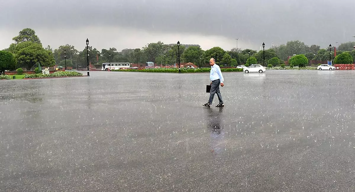 A man seen walking during a rainy day at Kartavya Path in New Delhi on Thursday