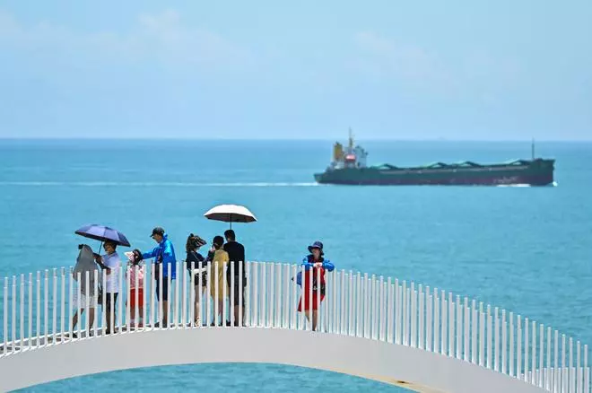 On the Chinese coast across from Taiwan, tourists gathered Friday to try to catch a glimpse of any military aircraft heading toward the exercise area (Photo by Hector RETAMAL / AFP)