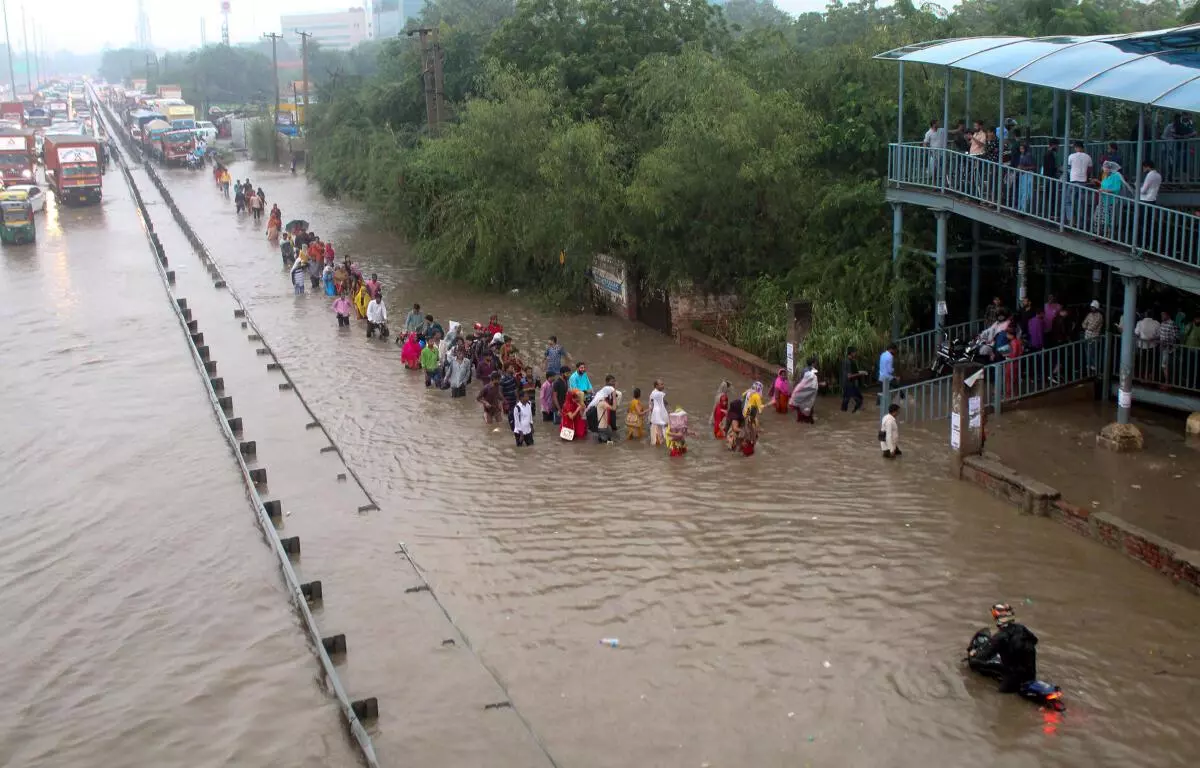 Commuters wade through the waterlogged Delhi-Gurugram Expressway  service road after rainfall, in Gurugram, Thursday, September 22, 2022. (PTI)