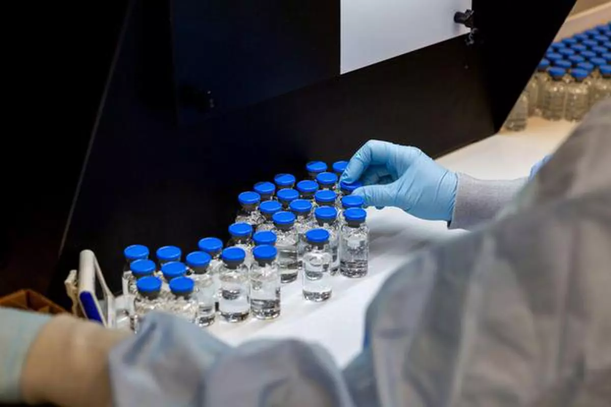 A lab technician inspects filled vials of investigational coronavirus disease (Covid-19) treatment drug remdesivir at a Gilead Sciences facility in La Verne, California
